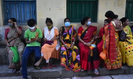People sit beside the road in Kolkata, India.