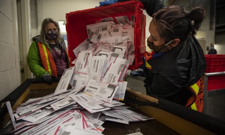 Election worker Kristen Mun empties ballots from a ballot box at the Multnomah county elections division in Portland.