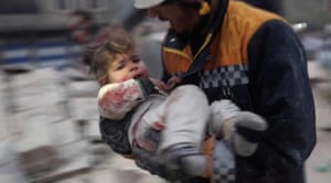 A rescuer carries an injured child away from the rubble of a building following an earthquake in rebel-held Azaz, Syria.