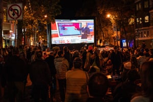 People watch results in the U.S. presidential election at a watch party in the Mission District
