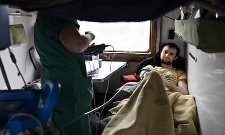 An MSF nurse cares for 30-year-old electrician Evhen Perepelytsia (R), who lost his leg to shelling in his hometown of Hirske in the eastern region of Luhansk.