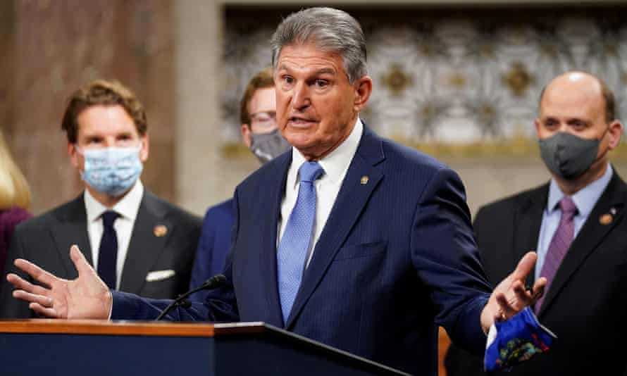 Senator Joe Manchin removes his mask to speak.