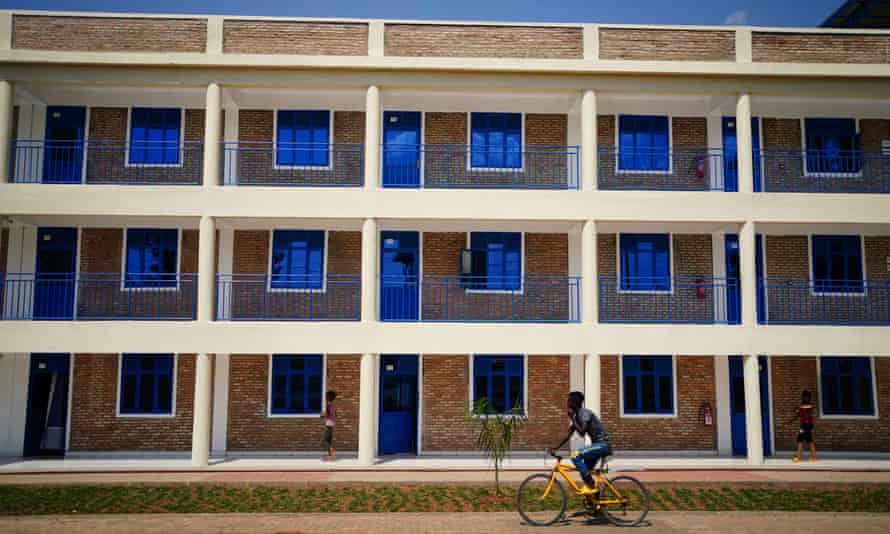 A resident cycles past a new accommodation block at the Gashora refugee transit centre, south of Kigali, Rwanda