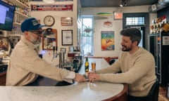 Two men on either side of a bar.