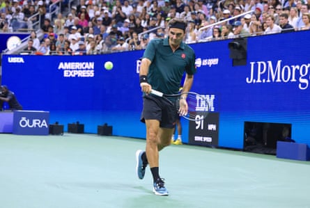 Roger Federer, in navy blue poloshirt and shorts, hitting a backhand on court