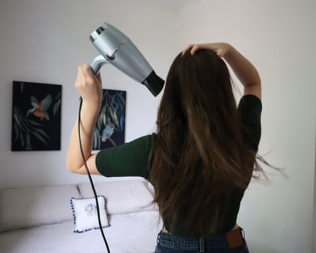 The writer dries her hair with a light green hairdryer