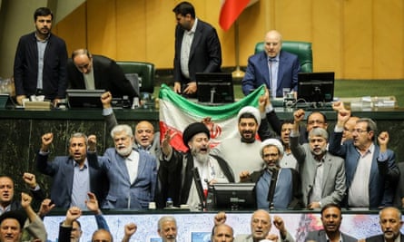 Lawmakers in Tehran chant slogans at an open session of the parliament in Tehran as Iran launched drones toward Israel.