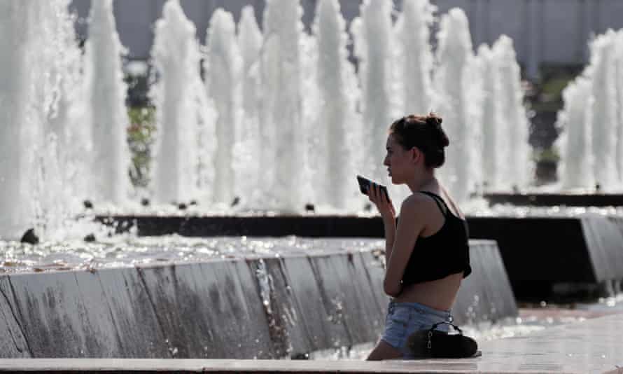 Una donna a una fontana nel centro di Mosca.