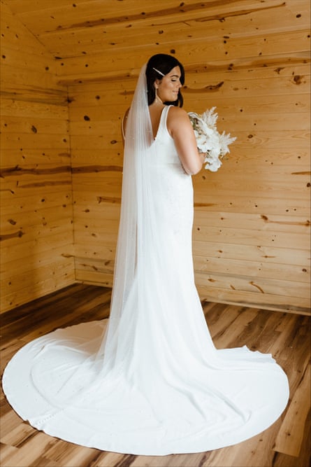 A woman in a full length wedding dress, from the back.