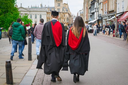 Graduating students walking on the street with their backs to camer