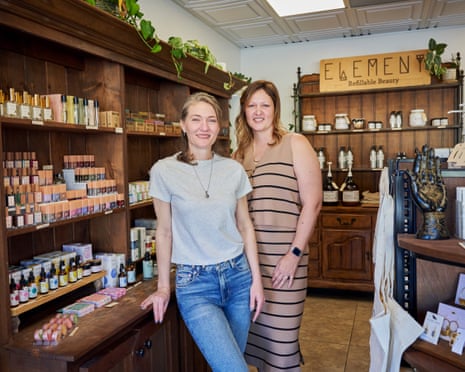 Two women smile inside the retail area of a salon.