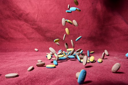 Cascading supplement pills connected a reddish background
