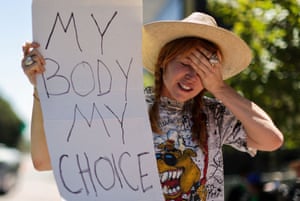 Eleanor Wells, 34 holds up a banner as abortion rights protesters demonstrate in Los Angeles.