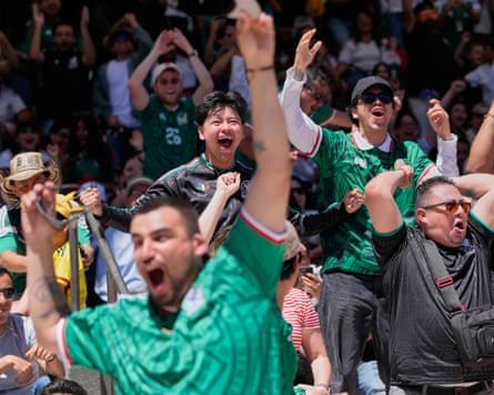 Mexico fans shout and jump in the air with their hands raised