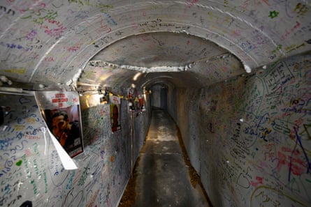 Túnel lleno de carteles y mensajes escritos a mano con rotulador.