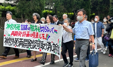 Protesters carry a banner that reads: ‘Please do not cut 1,000 trees at Jingu Gaien’