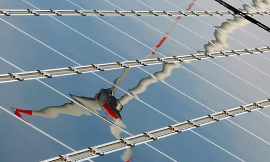Wind turbine reflected in solar panel
