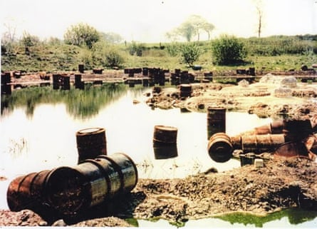 Chemical drums sitting in and around a lake