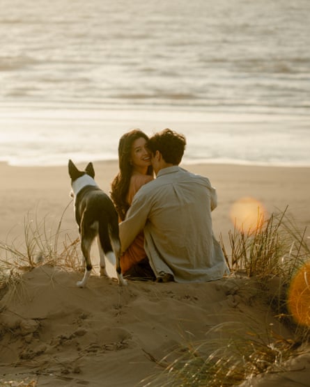 Moire, Tighe and their border collie sitting on a sand dune looking at the sea