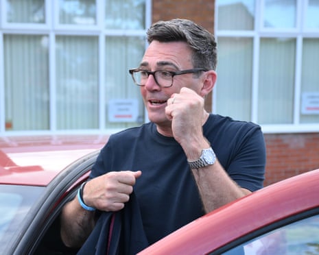 Andy Burnham holds up a fist as he steps into his car