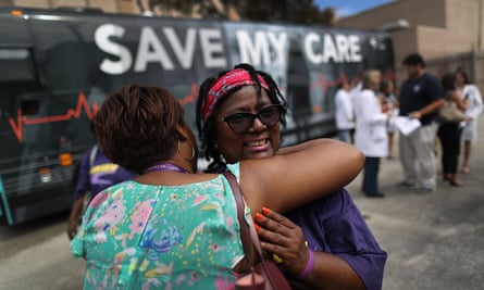 Margalie Williams, a cancer survivor, is hugged after speaking during a rally near Jackson Memorial hospital in Miami, Florida, as part of the Save My Care bus tour.