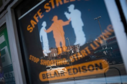 A blue-and-orange poster reads ‘safe streets, stop shooting, start living’.