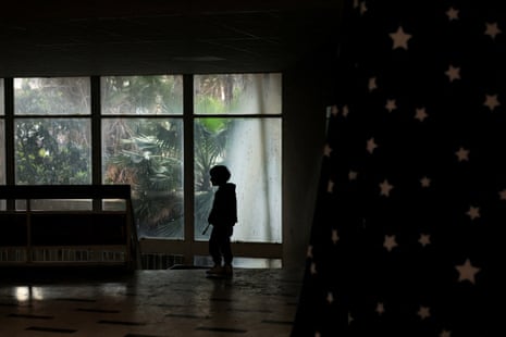 एक बच्चा आश्रय स्थल बने स्कूल में खड़ा है