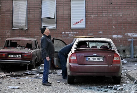 Local people check their damaged cars after a Russian strike in Kherson on 3 February.