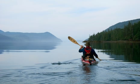 Guide Gord Pincock leads an early morning paddle on the calm waters in Gwaii Haanas, Haida Gwaii, Canada.