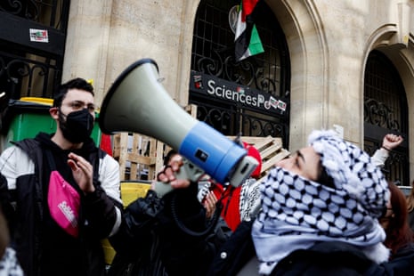 Masked youths take part in the occupation of a building of the Sciences Po University in support of Palestinians in Gaza in Paris.