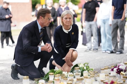 The Swedish prime minister, Ulf Kristersson, (L) and the Social Democratic party leader, Magdalena Andersson, visit the makeshift memorial.