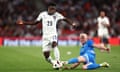 Bukayo Saka of England dribbles with the ball past an Iceland defender.