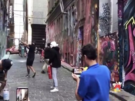The group spraying over graffiti art in Melbourne’s Hosier Lane.