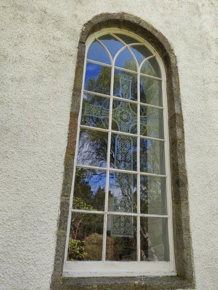 A church window etched with a Celtic cross