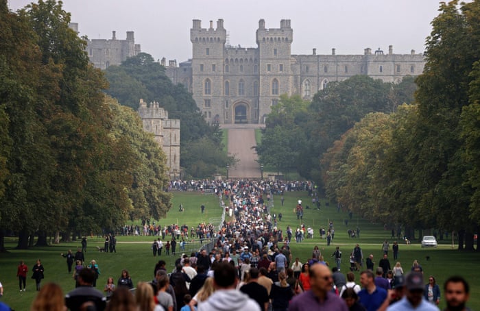 Members of the public walk along the Long Walk in Windsor Great Park, outside of Windsor Castle, west of London.