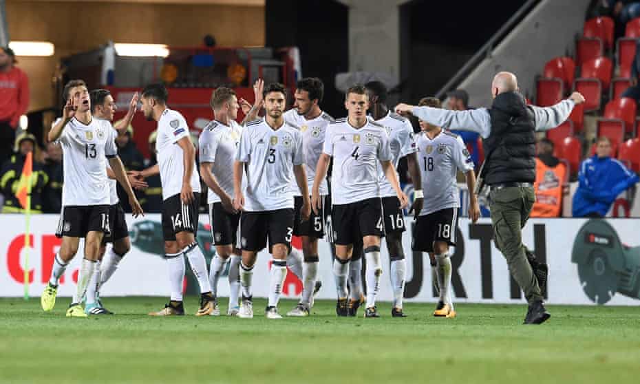 Germany’s players try to ward off the approaches of a supporter on the pitch after their win against the Czech Republic in Prague