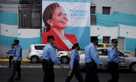 Honduras police officers walk past a poster with an image of Xiomara Castro outside the national stadium in Tegucigalpa, during the preparations for her swearing-in ceremony on Wednesday.