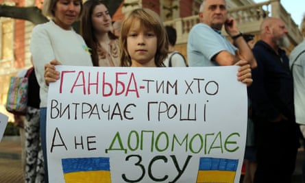 A child holds a banner calling against the misuse of budget funds by the city authorities near the city hall building in Odesa, Ukraine.