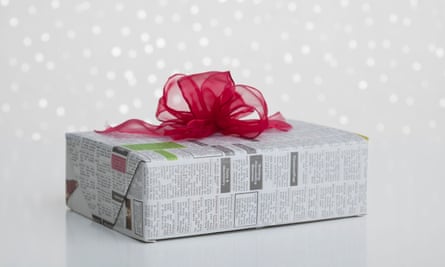 Studio shot of gift wrapped in newspaper on sparkled background