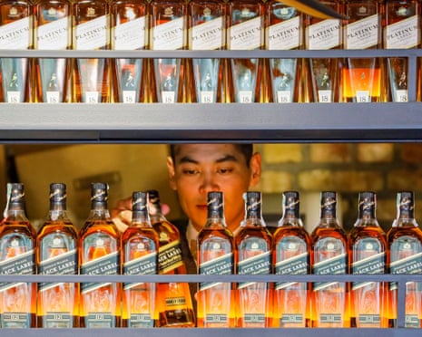 酒吧服務員拿起一瓶尊尼威士忌