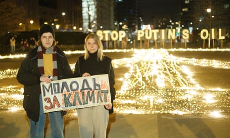 Ukrainians Ilyess El Kortbi (L) and Arina Bilai protesting in front of a ‘Stop Putin's oil’ sign outside the EU council building.
