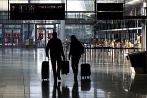 People walk through a deserted check-in hall at the airport in Munich