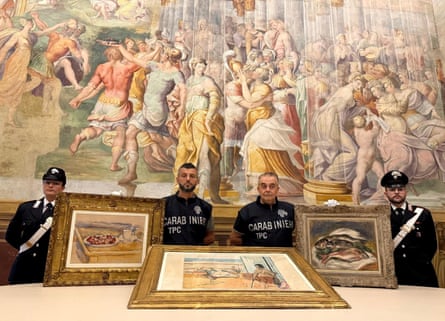 The Carabinieri stand with three recovered paintings by Cezanne, Matisse and Renoir.