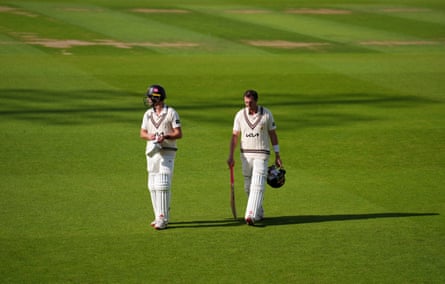 Surrey's Tom Lawes and Daniel Worrall walk off the field