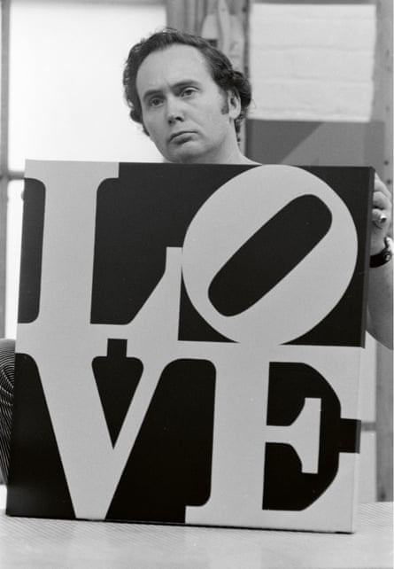 Robert Indiana holding his well-known Love print, in his Coenties Slip studio, circa 1964