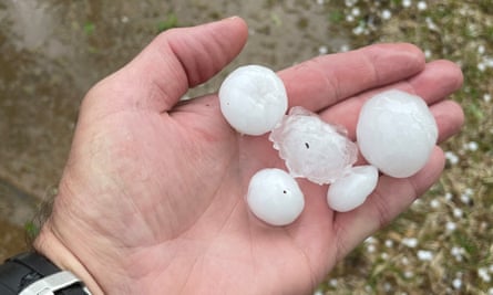 A person holds hailstones in their hand after a hailstorm in Hurst, Texas.