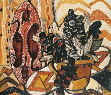 A vase of banksia in front paintings and items mimicking Aboriginal artwork