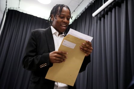 Teenager smiles as looks at letter in envelope