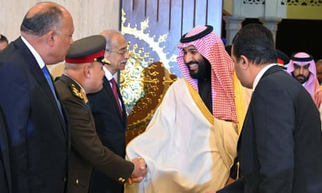 Crown Prince Mohammed bin Salman, centre, shakes hands with Egyptian officials on arrival in Cairo