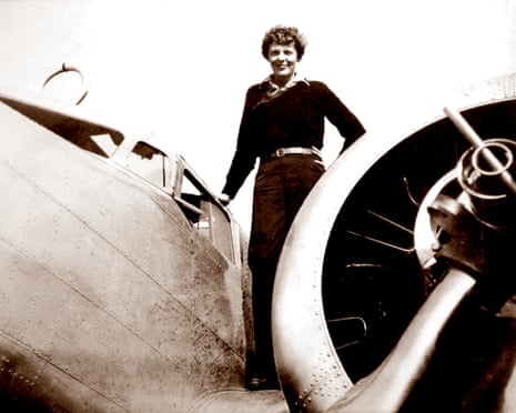 Amelia Earhart stands on her aeroplane's wing beside the engine propeller